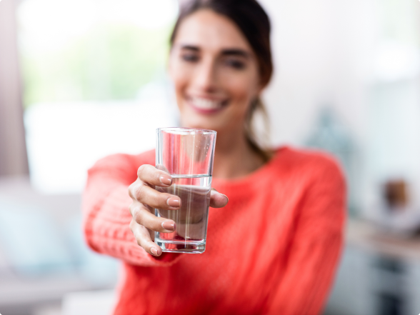 Woman holding out a glass of water